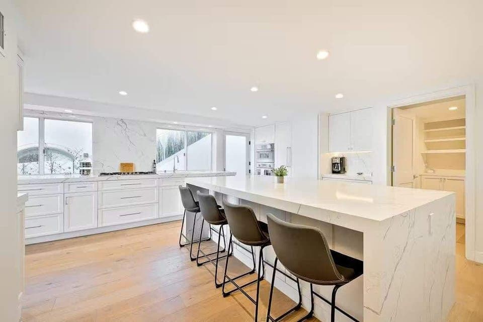 The well-equipped, sleek kitchen with stainless appliances and a large stone island