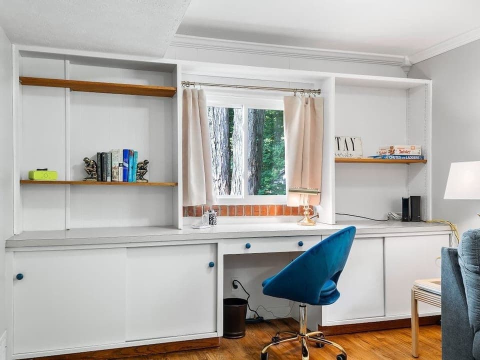 Dedicated workspace featuring built-in shelving, ample storage, and a comfortable desk chair perfect for remote work. 💻📚