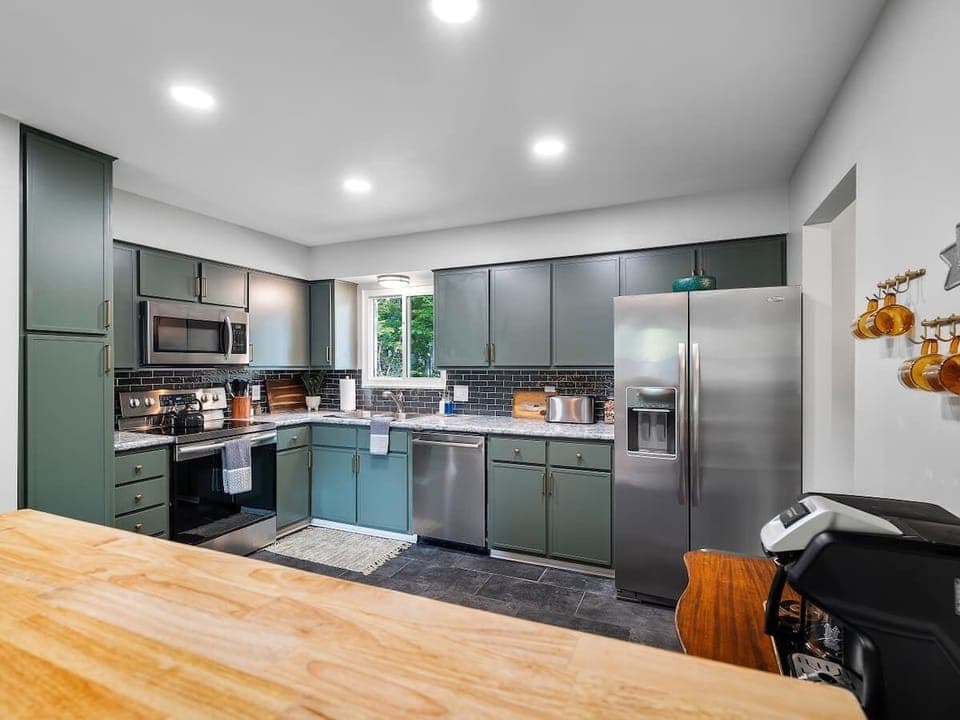 A thoughtfully designed kitchen, showcasing a harmonious blend of modern appliances and classic cabinetry.  The muted tones create a serene atmosphere. 