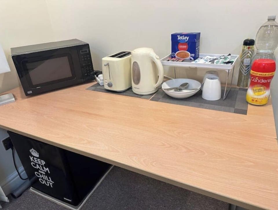 The kitchenette features a microwave, kettle, toaster, fridge, tea, and coffee.
