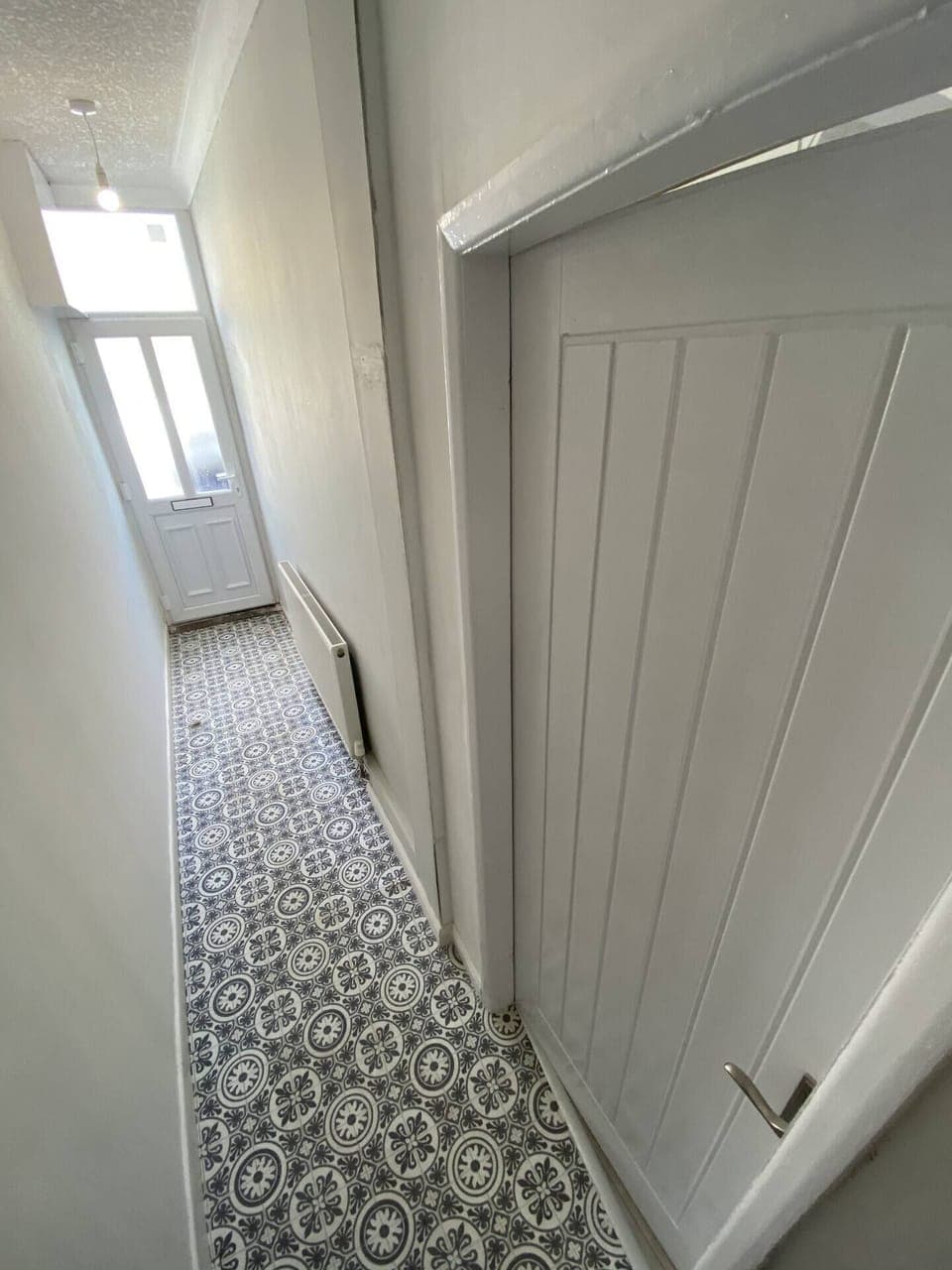Bright and welcoming entrance hallway with stylish tiled flooring and a clean, modern design.