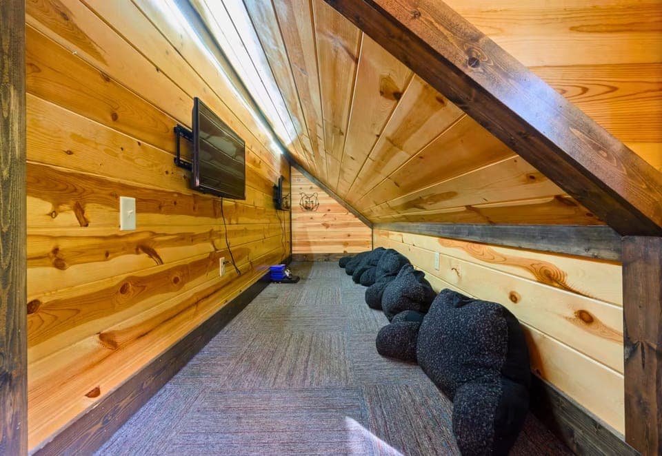 A cozy hideaway tucked under the loft offers a quiet spot to lounge, complete with soft beanbags for kids or adults to relax in style.