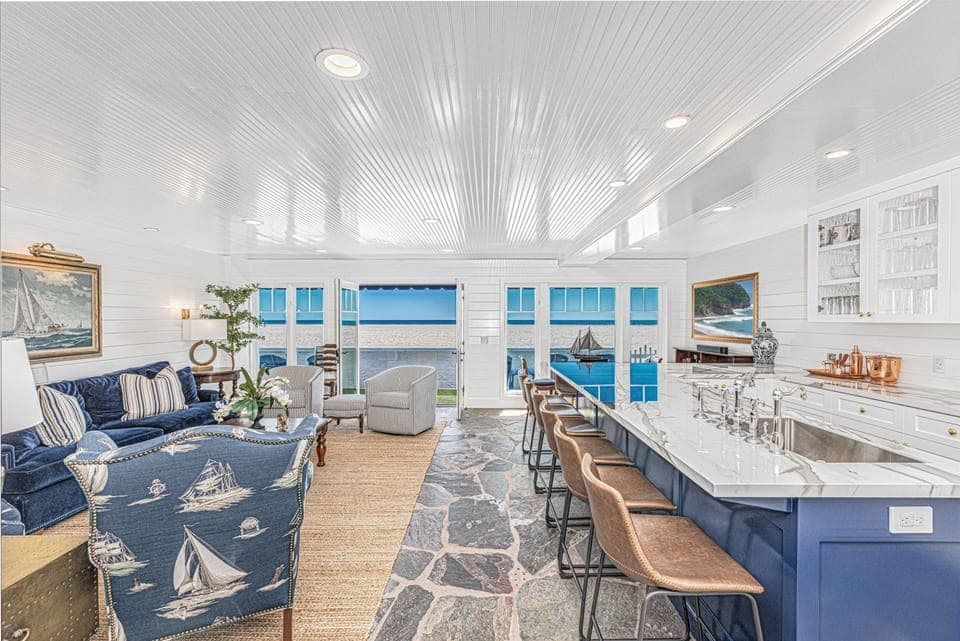 Bright open-concept living and kitchen area with ocean views and coastal-inspired décor
                