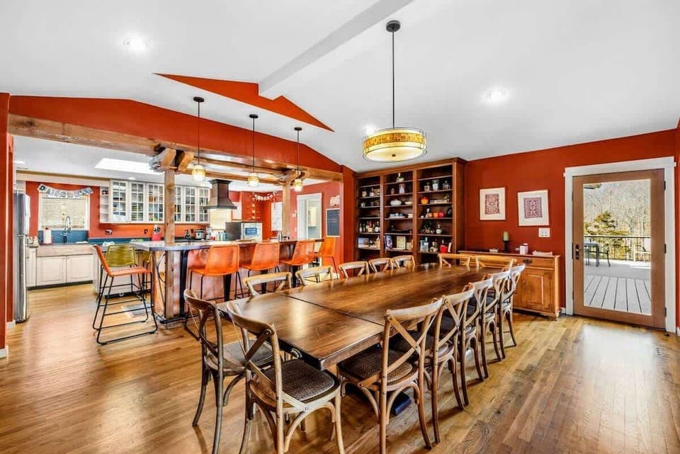 Elegant Dining Area with Deck Access - The spacious dining room features seating for 14, built-in shelving, and seamless access to the deck. The open layout connects to the kitchen and bar, making it perfect for gatherings and entertaining.