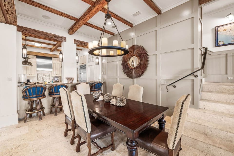 Gather around this stunning dining table under rustic beams and elegant lighting for memorable meals and conversations.