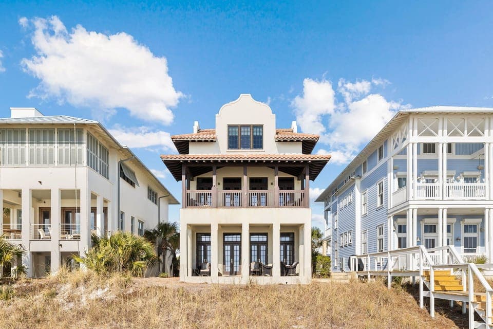 Stunning beachfront homes create a charming coastal neighborhood with distinctive architecture and natural dune landscaping.