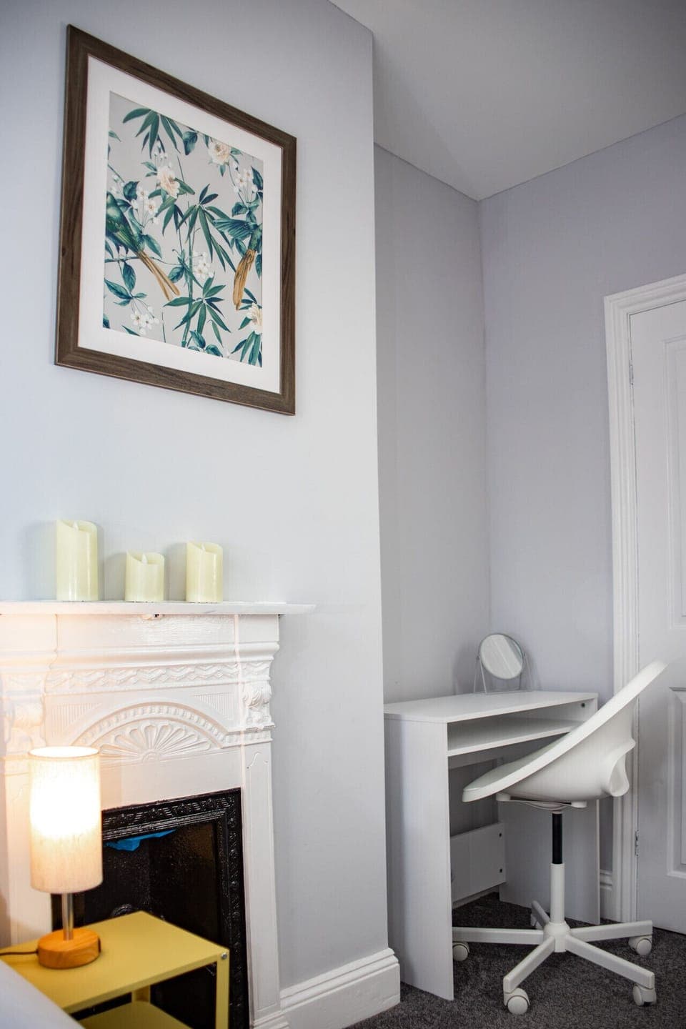 Bright bedroom with feature fireplace, desk area and elegant, contemporary styling.