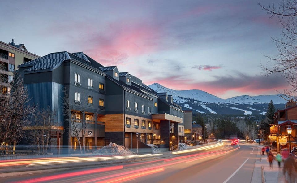 As the sun sets, the town comes to life with warm lights, scenic streets, and a cozy mountain-town atmosphere.