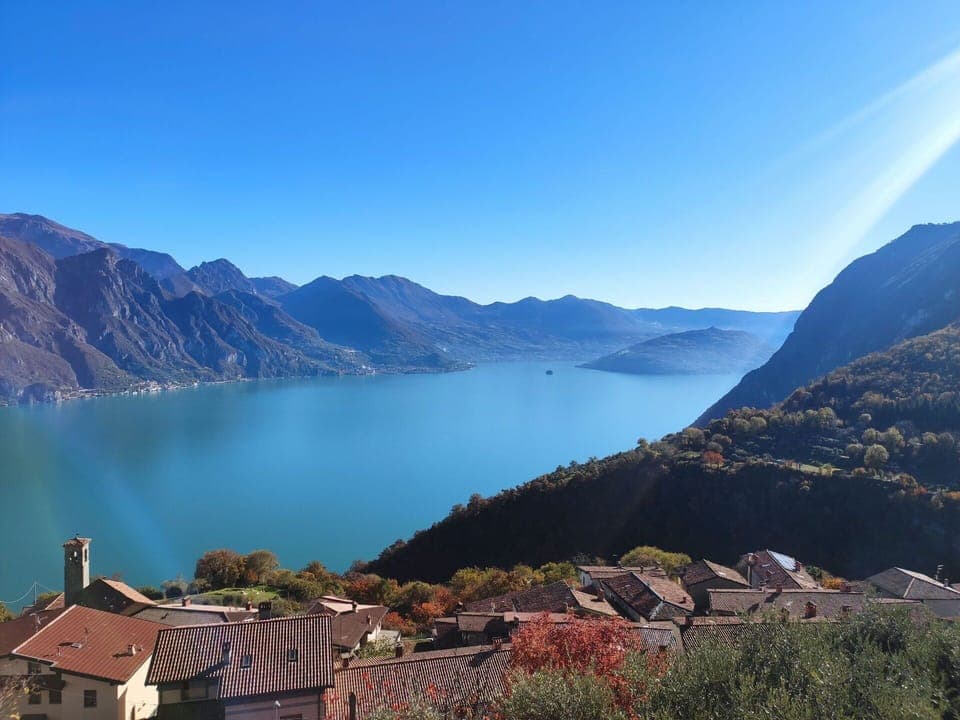 Water, Sky, Mountain, Building, Natural Landscape, Highland, Plant, Tree, Lake, House