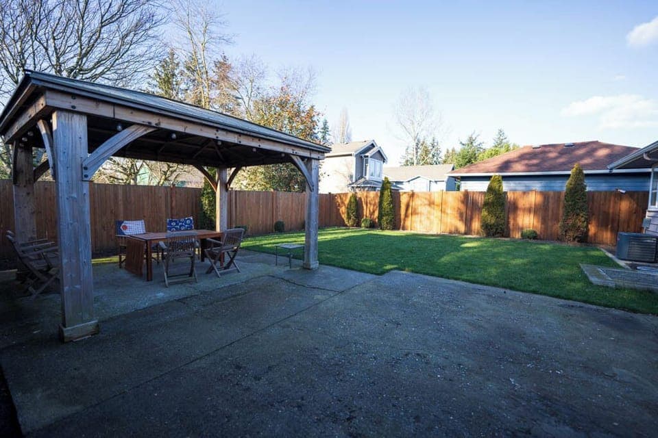 Fully fenced back yard with outdoor seating.