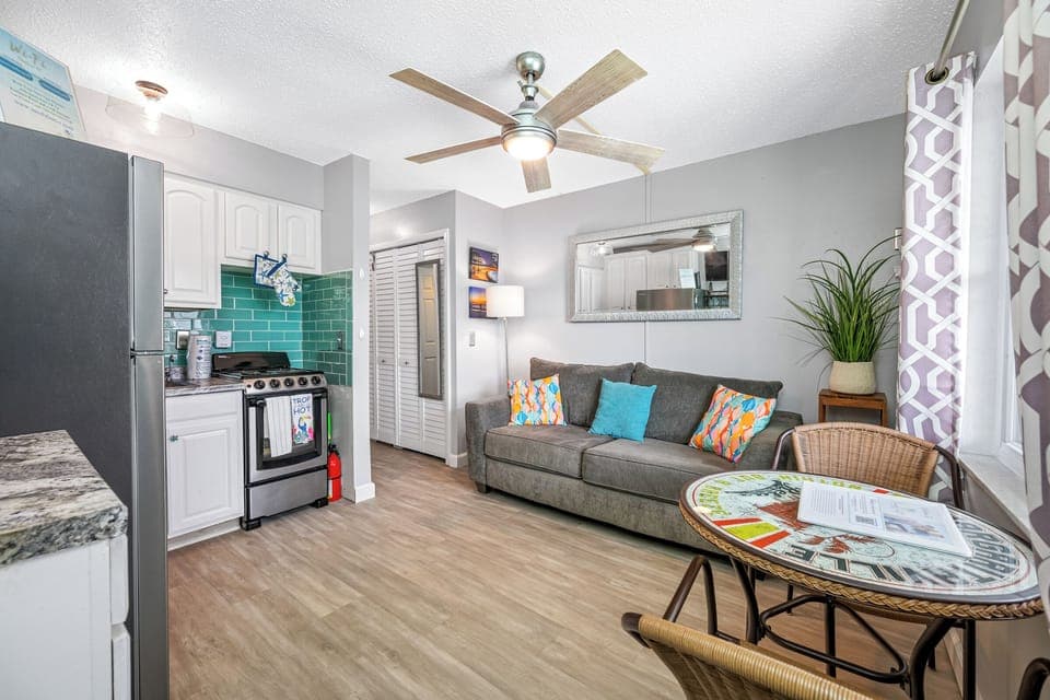 Spacious lounge area with a cozy couch, decorative pillows, and a charming dining corner.