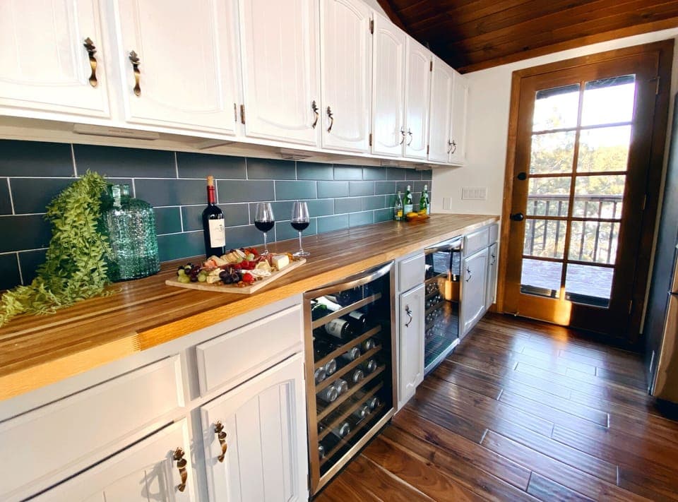 bar and two beverage fridges, door leads to the outdoor deck