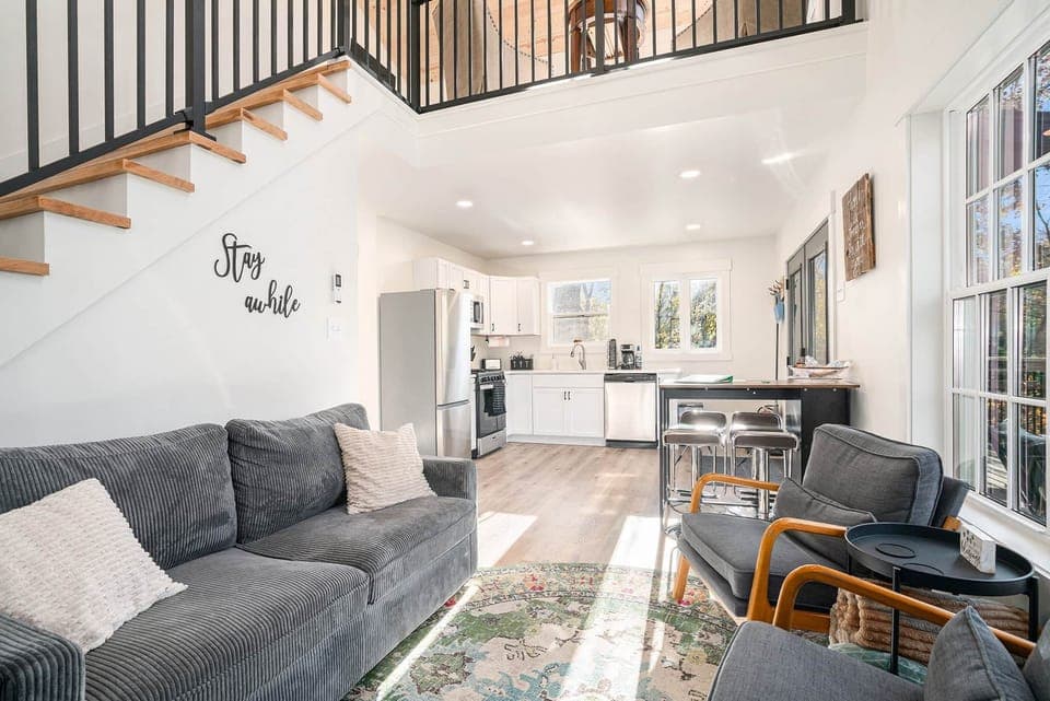 Open-concept living room with forest views and cozy seating. Also includes pull-out bed in couch.