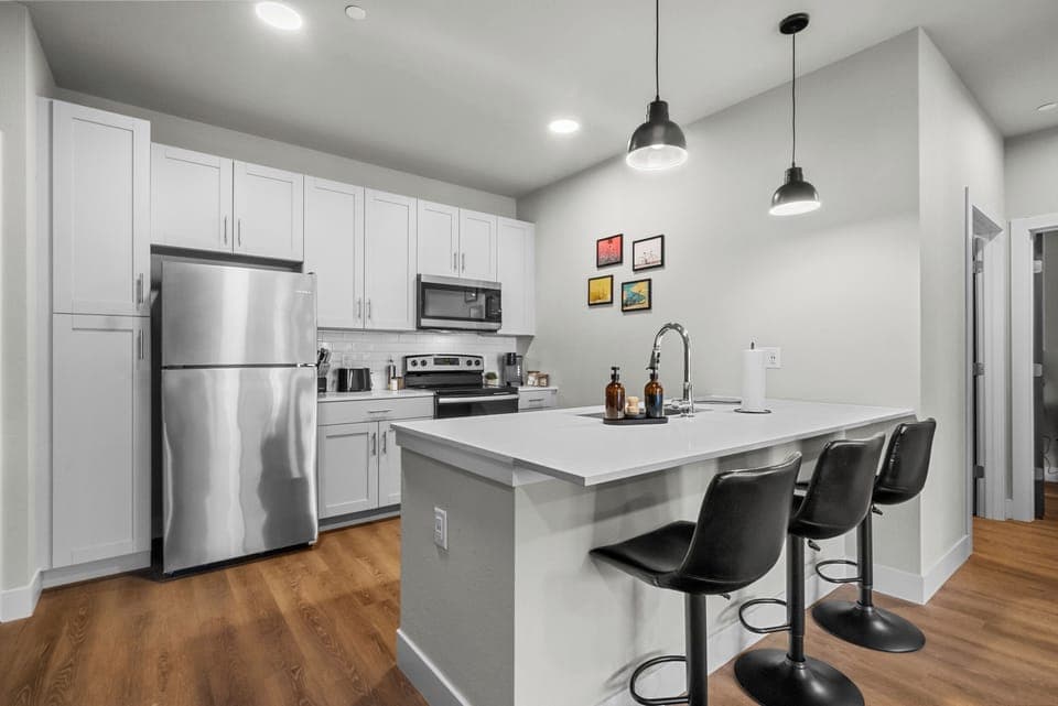 The fully equipped kitchen features sleek, modern appliances and ample counter space, making it easy to prepare your favorite meals or a simple cup of coffee!