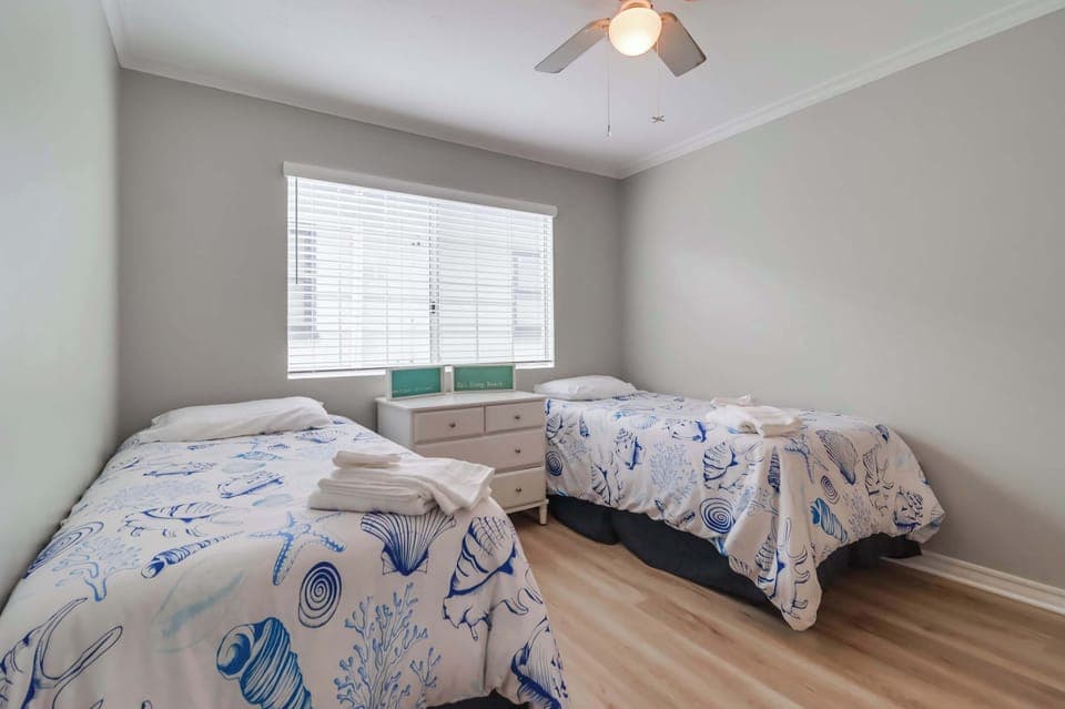Second floor bedroom with two single beds, central A/C, closet and ceiling fan.
