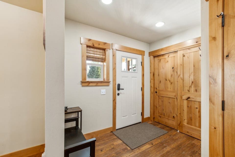 Front door with lots of places to hang coats and place shoes/boots