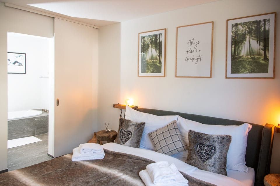 Bedroom with a double bed and integrated bathroom with a bathtub