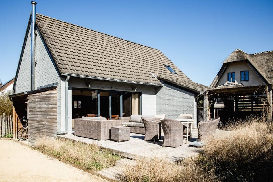Exterior view of the villa and garden with outdoor seating