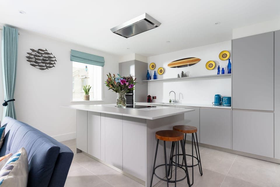 1 Cliff Edge, Newquay: The kitchen is fully equipped kitchen with modern appliances, including a wine fridge, induction hob, and remote-controlled extractor fan