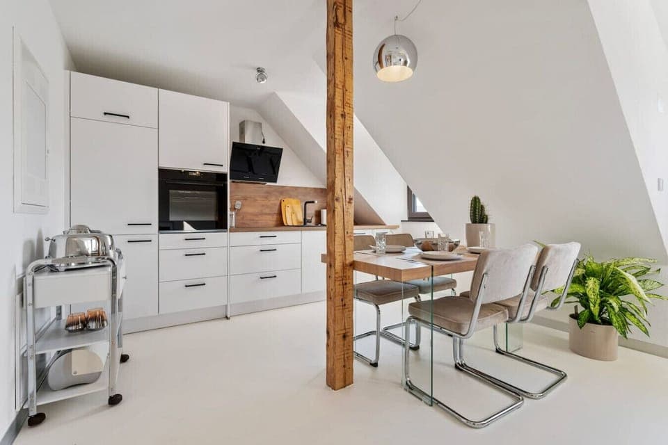 Die geräumige offene Küche  und der Essbereich im unterem Teil der Maisonette Wohnung.