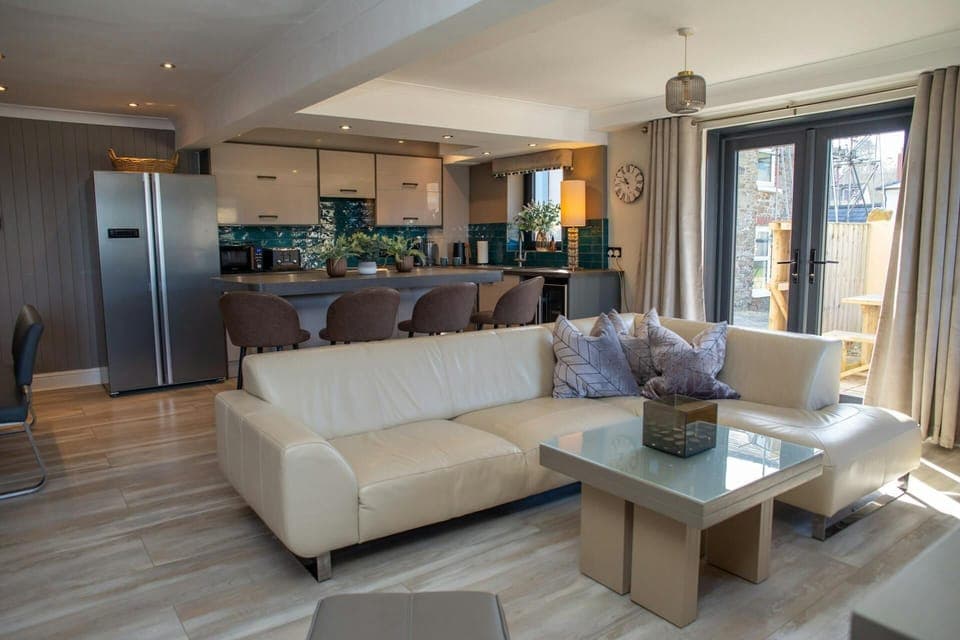 Lounge area with large sofa and doors leading to the patio area