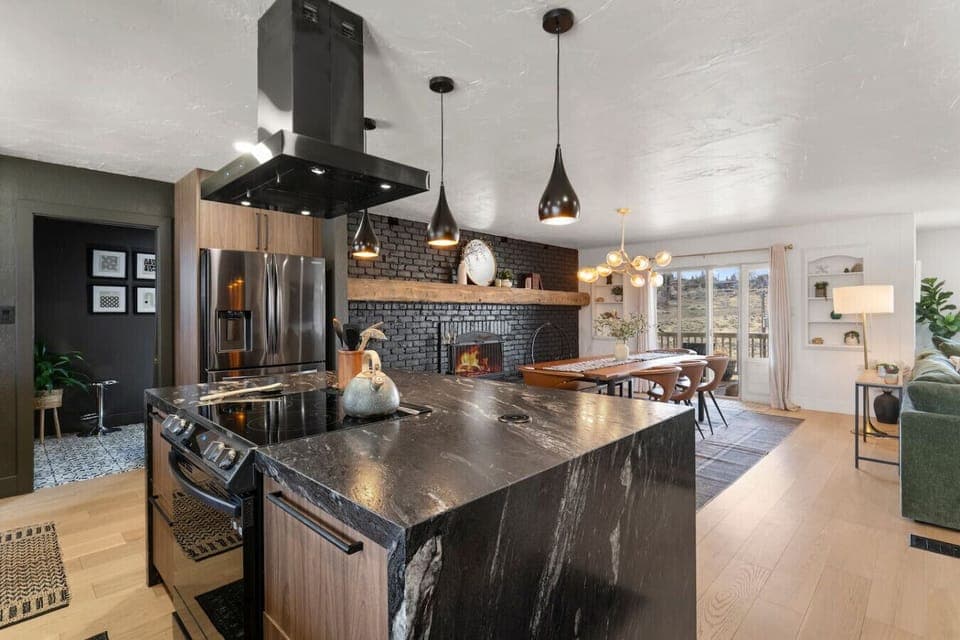 Cook, dine, and unwind in style! This open-concept kitchen flows seamlessly into the dining and living areas, featuring a sleek island, modern appliances, and a cozy fireplace view.