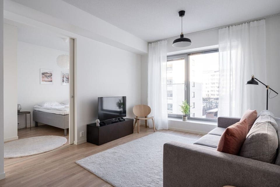 Apartment living room is spacious and bright. There is a bed sofa in the living room.