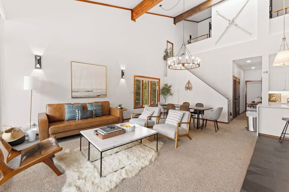 Living area featuring ample seating, flat-screen TV, wood burning fireplace, and balcony access.