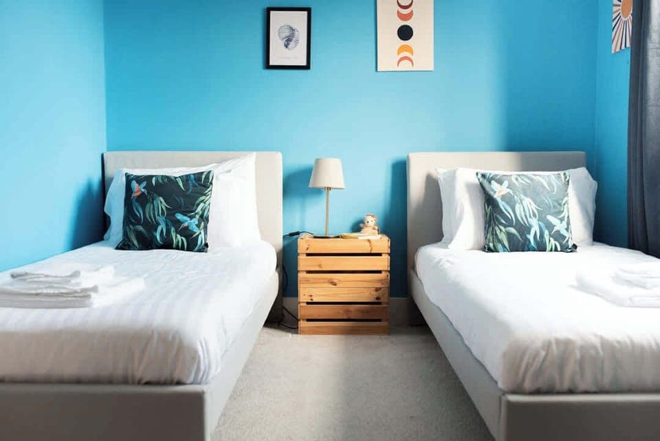 two separate beds in this serene blue room offer the perfect balance of comfort and tranquility