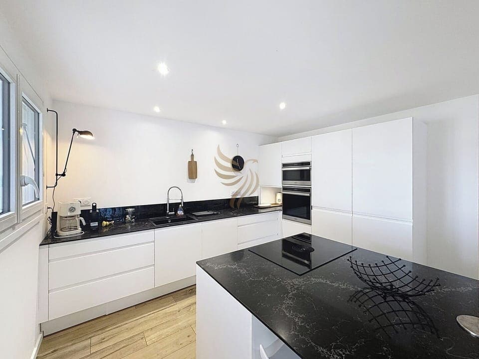 La cuisine spacieuse comprend un îlot central parfait pour cuisiner ensemble. Les espaces de rangement intégrés optimisent l'organisation, rendant cette pièce idéale pour les amateurs de cuisine et de design moderne.