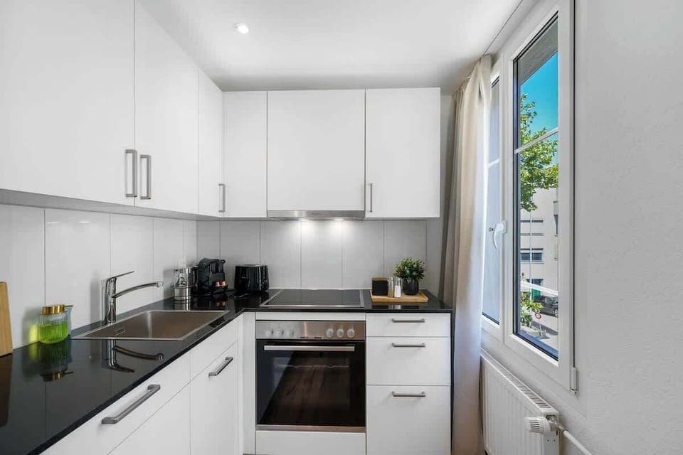 Voll ausgestattete Küche mit Spülmaschine, Backofen und Herd