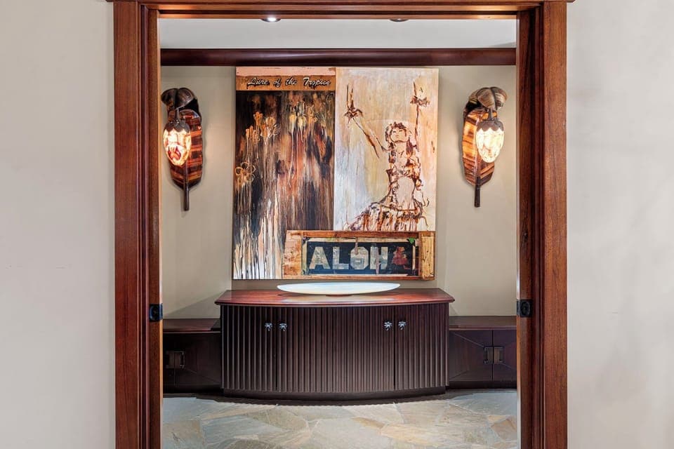 A beautifully designed entry to the primary suite, accented with Hawaiian artwork and custom wood finishes.