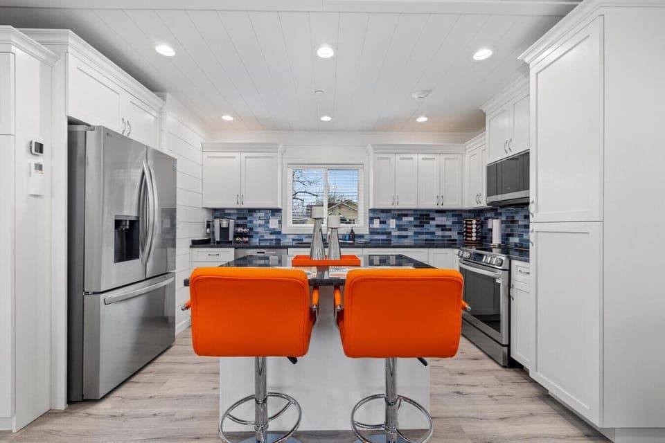 Beautiful modern kitchen with island seating and stainless steel appliances.