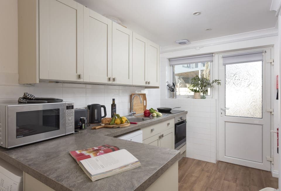 Bluebirds, Polzeath: The kitchen is superbly equipped with an oven, hob, microwave, fridge, dishwasher, and washing machine