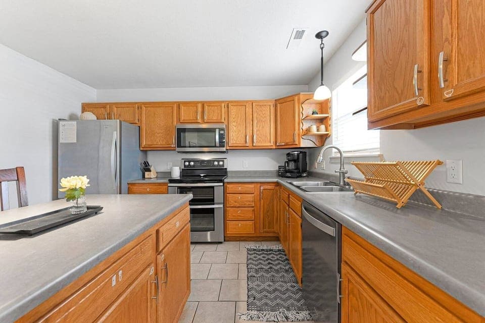 Functional kitchen with warm wood cabinetry, ample counter space and modern appliances.