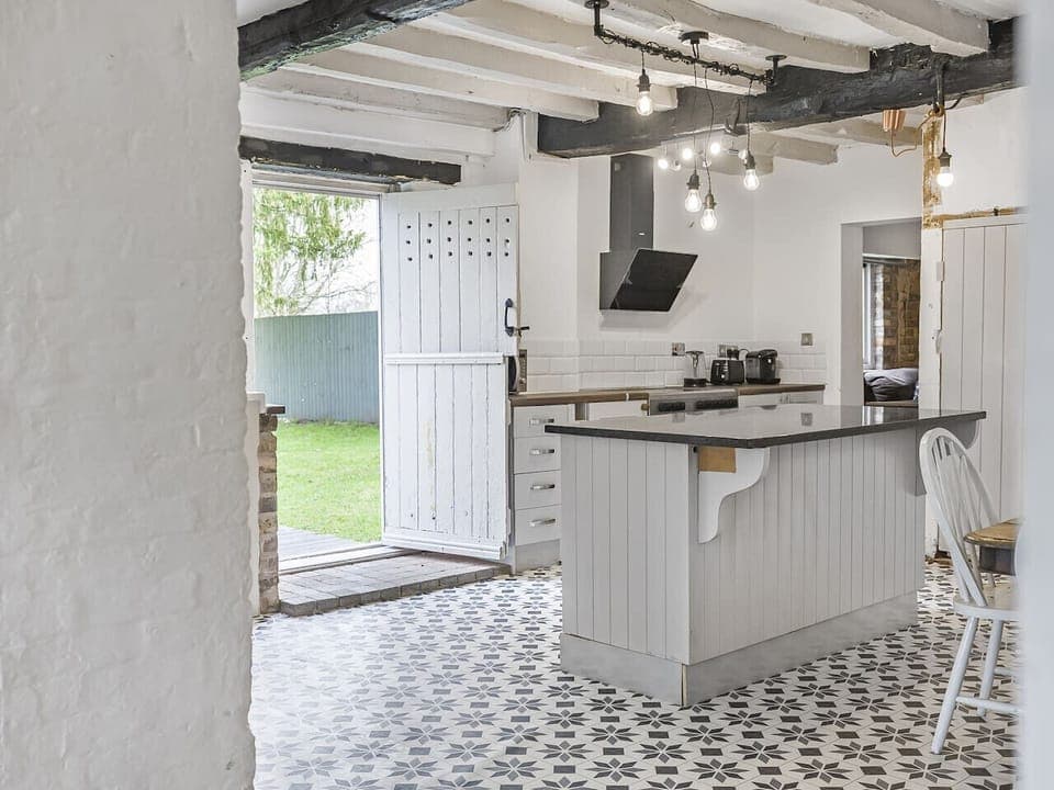 Equipped open plan kitchen with dining table opening up to the garden