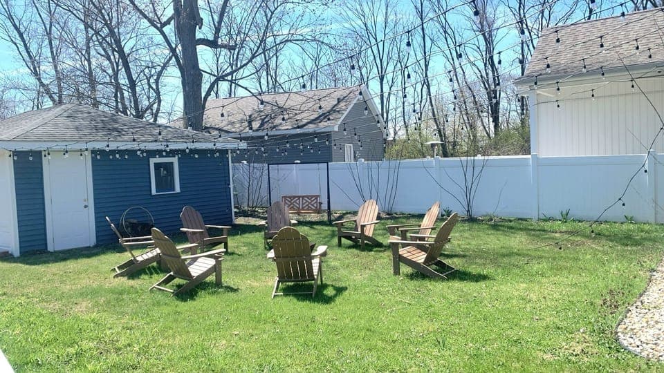Backyard with adirondack chairs and grassy lawn