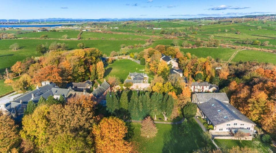 Aerial view of a property amidst vibrant autumn foliage.
