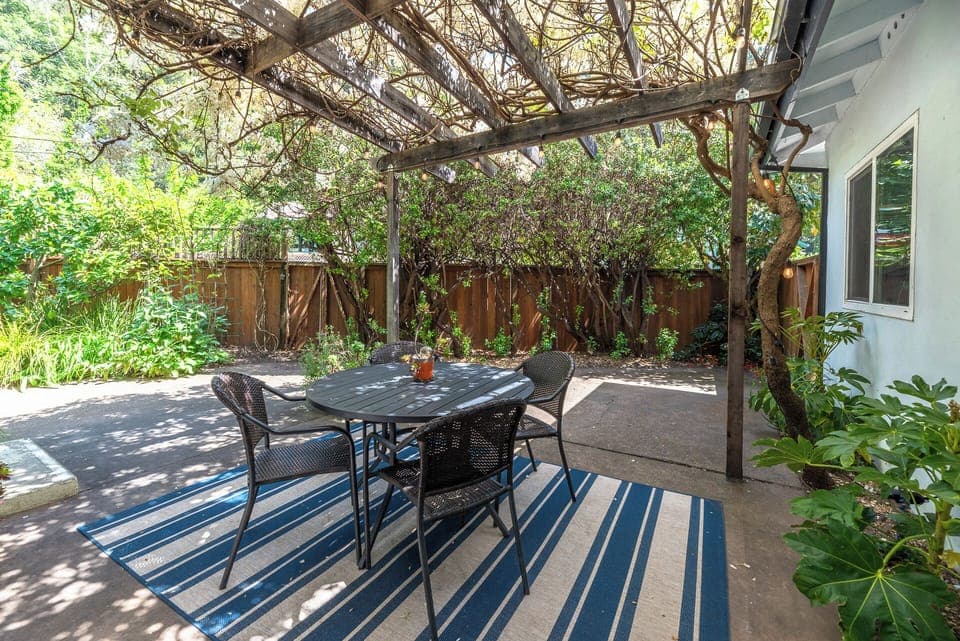 Outdoor dining is a joy under the cool shade of - the wisteria vine.