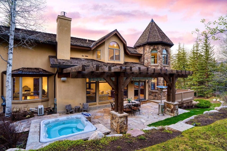 Backyard with a hot tub and outdoor dining table.