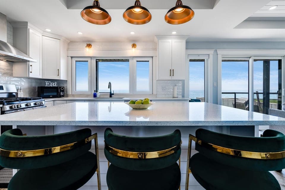 A glass-top dining table under a cascading modern chandelier
