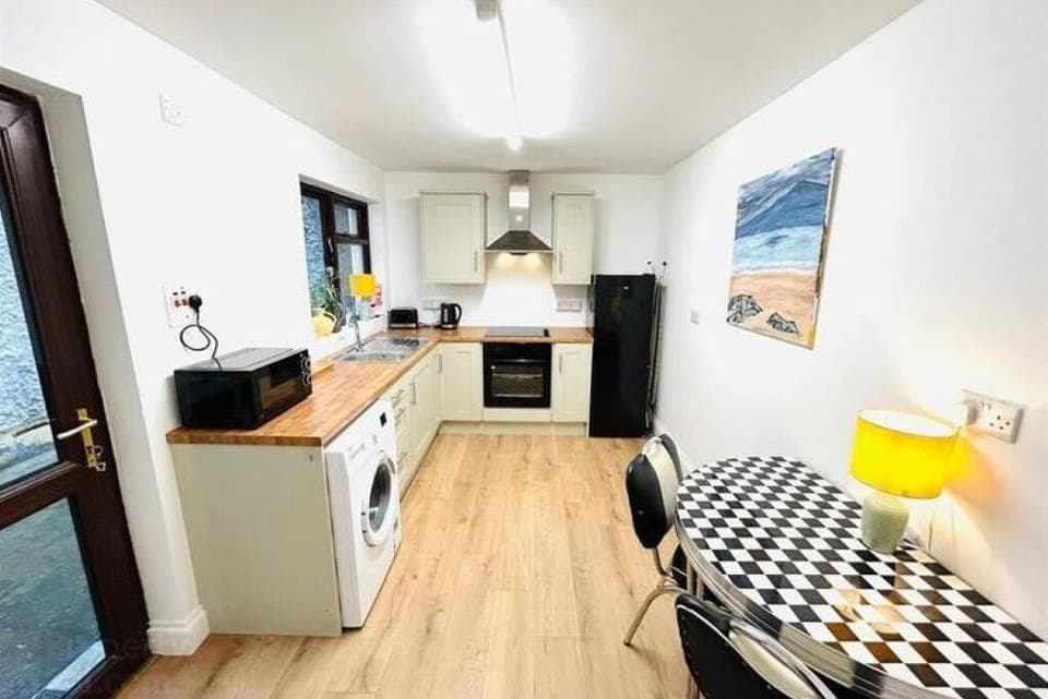 kitchen with washing machine, fridge freezer, microwave, radio, oven