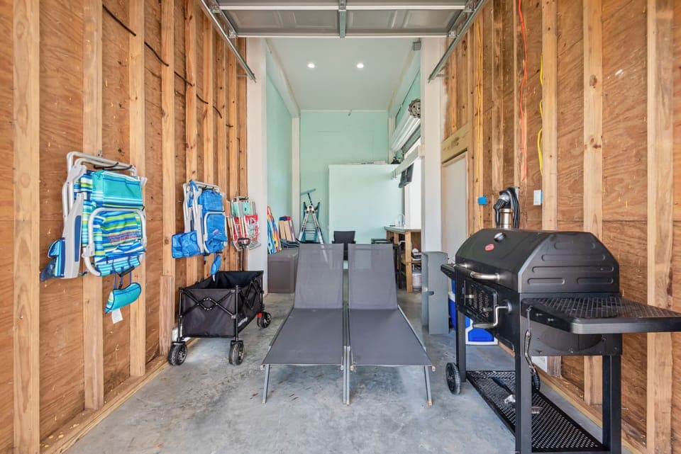 Garage packed with beach toys, grill, and chairs