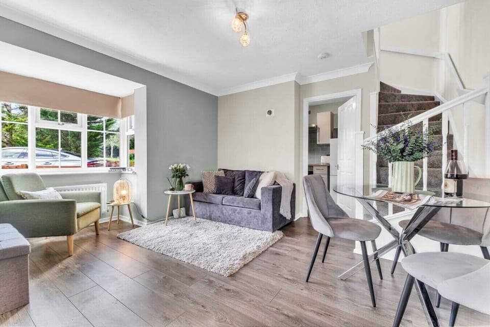 Relax in the open-plan living and dining area, complete with a 50” Smart TV, a plush sofa, and a cozy armchair—perfect for unwinding after a busy day.