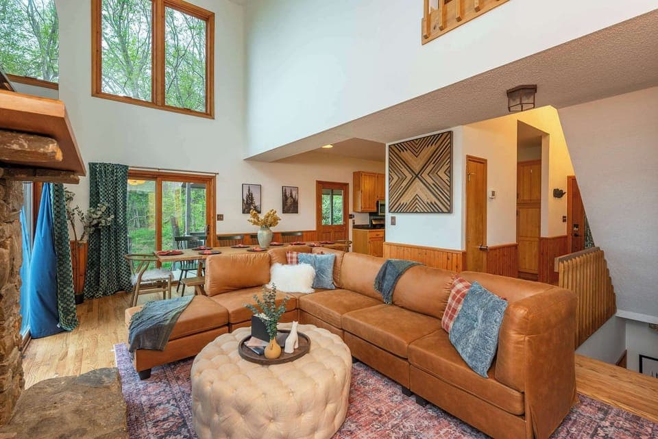 As you enter, you’ll be welcomed by our stunning and cozy living room featuring a large plush leather sofa and a warm indoor fireplace—perfect for relaxing and gathering.

