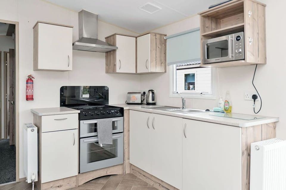 Modern kitchen with a gas stove, microwave, and ample storage—well-equipped for preparing meals with ease.