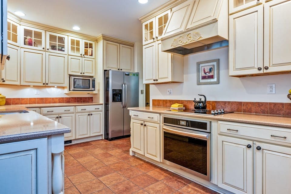 Elegant chef’s kitchen featuring custom cabinetry, granite counters, and stainless-steel appliances—perfect for cooking and gathering.