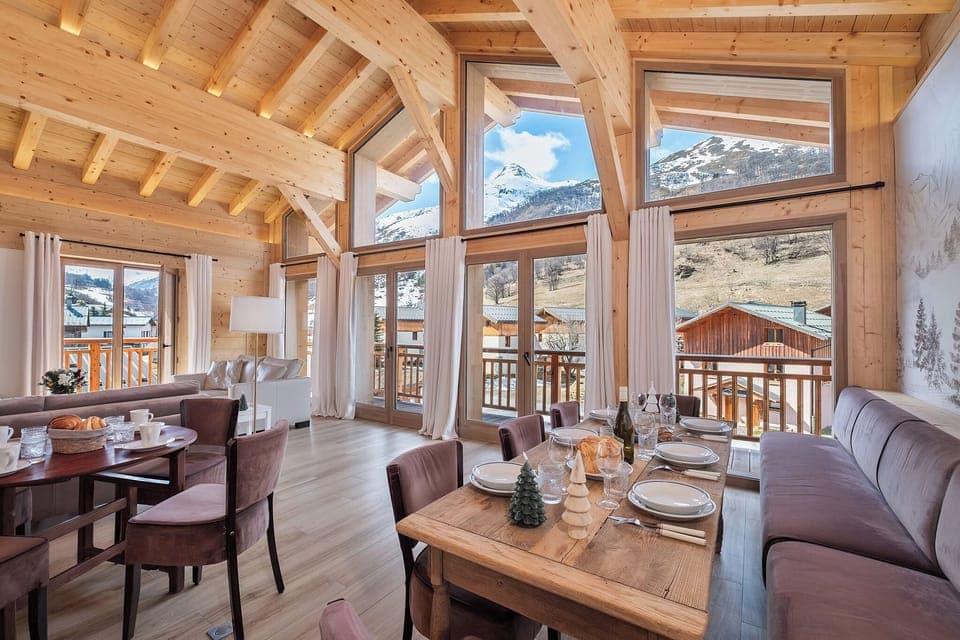 Bright living room with panoramic mountain views and magnificent cathedral bay windows.