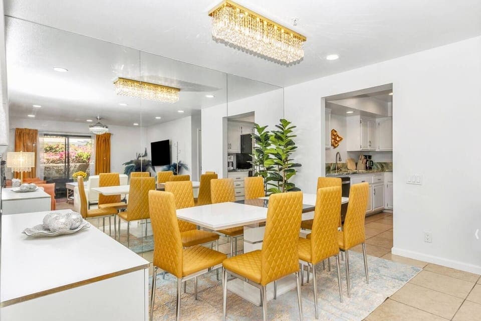 Enjoy meals around a beautiful 8-seat table beneath a stunning chandelier. Surrounded by elegant decor and a vibrant LOVE painting.