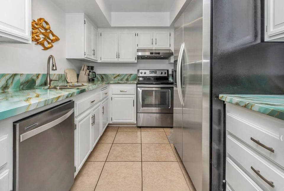 Fully equipped kitchen features all the essentials—including a large refrigerator, stove, microwave, dishwasher, coffee maker, complete cookware and plenty of dishes and glasses—perfect for preparing meals and enjoy it.